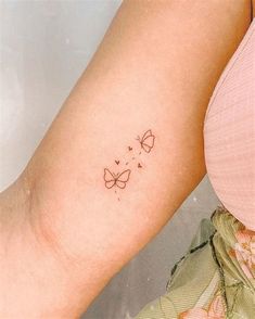 a woman with a butterfly tattoo on her left arm and the word love is written in small letters