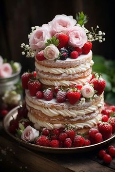 a wedding cake with strawberries and roses on top is sitting on a wooden table