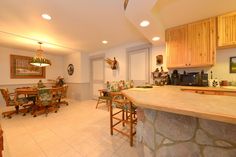 a kitchen filled with lots of counter top space and wooden cabinets next to a dining room table