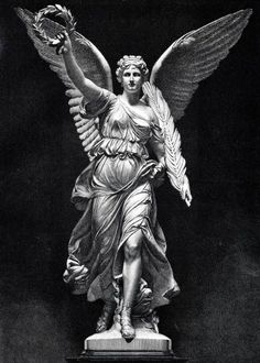 an angel statue is shown with its wings spread out, and it looks like she's holding something in her hand