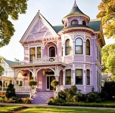 a very pretty pink house in the middle of some grass