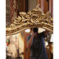 a man is taking a photo in front of a mirror with his cell phone up to his ear