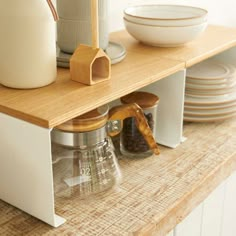 the kitchen counter is organized with coffee cups and utensils