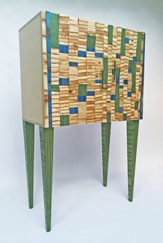 a small wooden cabinet with two legs made out of wood and green paint on it