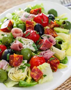 a white plate topped with salad and lots of toppings on top of a woven place mat