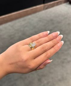 a woman's hand holding an engagement ring