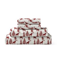 three sheets with red deers and pine trees on them, one is folded in white