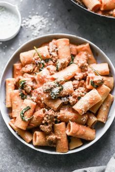 two bowls filled with pasta and meat sauce