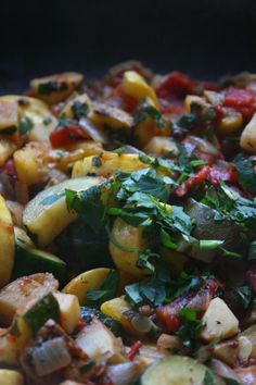 a close up view of some food in a pan with greens on top and red sauce