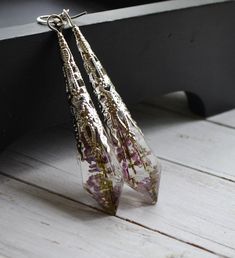 Gentel elven style earrings. Real dried purple Heather flowers captured inside resin crystal. According to legends these wonderful plant has many magical properties These earrings would make a great gift for the elven lady, real fairy or any nature lover. ITEM DETAILS Length: approx.6 cm/2.4 in Earrings are very lightweight. Elven Style, Real Fairy, Real Flower Earrings, Real Fairies, Elven Jewelry, Purple Heather, Style Earrings, Earrings Dangle, Real Flowers