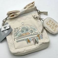 a star wars purse with a key chain and badge on the front, sitting on a white surface