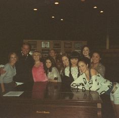 a group of people posing for a photo in front of a piano