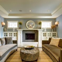 a living room with two couches and a coffee table in front of a fireplace