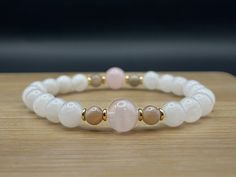 This natural gemstone bracelet is made using genuine Pink Rose Quartz, Grey Moonstone, and White Jade. This handmade piece is perfect for those who appreciate the unique energy of natural stones. Each bracelet is one-of-a-kind, with stones carefully chosen for their distinct character and appeal. * Ethically Sourced: We get our beads from a supplier we feel good about supporting so you can feel good about wearing them. These stones are certified Fair Trade and sustainably mined. * Handcrafted: Each bracelet is lovingly handmade by us and each one is a high quality finished piece that will hold up to being adored. * Gift Ready: We package our bracelets in ready-to-wrap gift boxes that are perfect for any occasion. Sizing: 1. Take a small string (or measuring tape) and wrap it around your wr Handmade White Rose Quartz Bracelet, Elegant White Rose Quartz Crystal Bracelet, White Rose Quartz Beaded Bracelets As Gift, White Rose Quartz Beaded Bracelet As Gift, White Rose Quartz Crystal Bracelet As A Gift, Handmade White Rose Quartz Crystal Bracelet, Adjustable White Rose Quartz Beaded Bracelets, Adjustable White Rose Quartz Crystal Bracelet, White Rose Quartz Bracelets With 8mm Beads