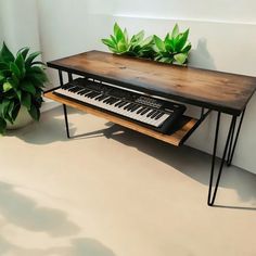 a table that has a keyboard on top of it next to a potted plant