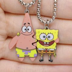 two cartoon characters are shown on a keychain that is being held in someone's hand