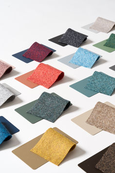 many different colored pieces of cloth on a white surface