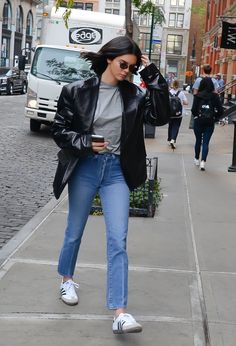 a woman walking down the street while talking on her cell phone