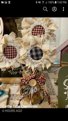 a vase filled with lots of fake flowers on top of a table next to a clock