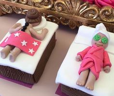 there are two small cakes shaped like people on the beds with pink and white frosting