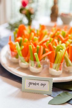 carrots and celery sticks are arranged on a plate with a name tag