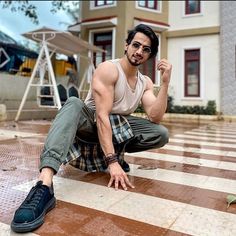 a man sitting on the ground in front of a house