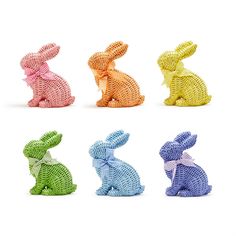 four different colored plastic rabbits sitting next to each other