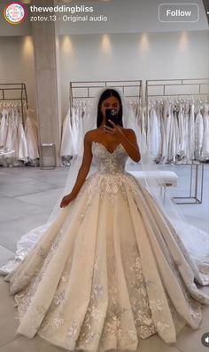 a woman standing in front of a wedding dress