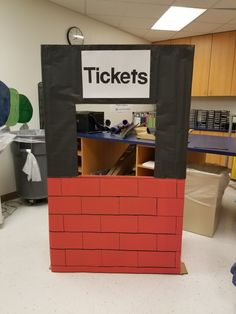 a red brick wall with a sign that says tickets on it in the middle of a room