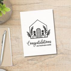 congratulations on your new home card with envelope and pen next to it, surrounded by office supplies