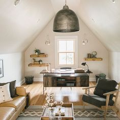 a living room with two couches and a desk in the middle of the room