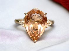 a fancy ring with an orange diamond in the center