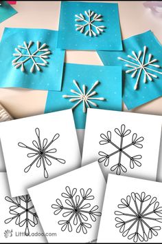 four snowflakes are shown on the table with some paper and glue to make them