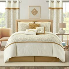 a bed with white and gold comforters in a bedroom