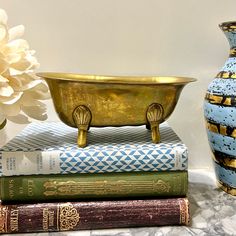 three books stacked on top of each other next to a vase