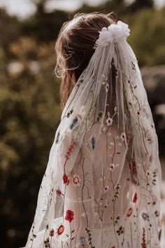 a woman wearing a veil with flowers on it