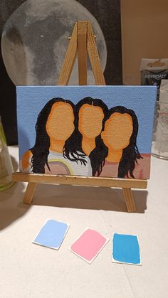 an easel with three women painted on it