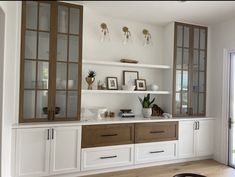 a kitchen with white cabinets and wooden flooring next to a sliding glass door that leads to an outside patio