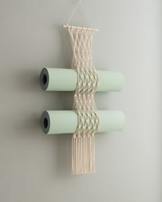 three rolls of paper hanging on a wall next to each other with some string attached to them