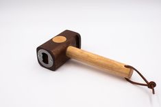 a wooden object with a hole in the middle and a cord attached to it, on a white surface