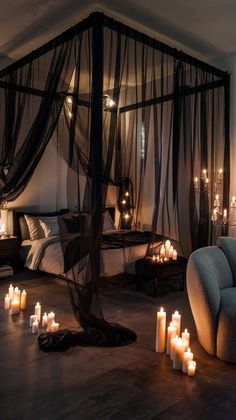 a bedroom with candles on the floor and a canopy bed