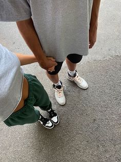 two people standing next to each other with their feet on one another's legs