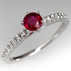 This pretty ring is centered with one (1) round mixed cut natural ruby set into a six-prong setting. The top face of the shank is accented with seven (7), prong set, round brilliant cut diamonds on each side. The ring measures 6.2mm at the top, rises 7.3mm above the finger, tapering to 1.3mm wide and 0.8mm thick at the base of the shank. This ring is currently a size 7. Timeless Ruby Ring With Diamond Prong Setting, Round Ruby Ring With Prong Setting, Ruby Birthstone Ring With Round Cut, Lab-created Ruby Diamond Ring With Brilliant Cut, Dazzling Ruby Ring With Prong Setting For Promise, Dazzling Ruby Promise Ring Round Cut, Timeless Ruby Ring With Round Cut Center Stone, Timeless Round Cut Ruby Diamond Ring, Ruby Ring With Round Stone And Prong Setting