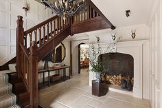 a staircase leading up to a living room with a fire place in the center and a fireplace