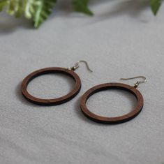 "These earrings are handmade using natural woods including walnut, maple, oak, cherry, Padauk, Purpleheart, mahogany, ash, elm, sycamore and more! For our signature striped design, individual pieces of wood are glued together then cut out in various shapes. Striped not your thing? We have our same design in solid walnut, cherry or maple. They are sprayed with a water-resistant finish. Ear wires are nickel-free, antique-plated brass. Handmade in Iowa. They are 1.75\" round with a drop length of a Handmade Wooden Earrings For Everyday, Handmade Wooden Earrings For Everyday Wear, Everyday Handmade Wooden Earrings, Minimalist Brown Hoop Earrings For Gift, Everyday Brown Wood Earrings, Handmade Wooden Jewelry, Solid Walnut, Color Blending, Wooden Jewelry