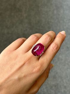 Make a statement with this unique and beautiful pink, sugarloaf shaped rubellite tourmaline and diamond three stone cocktail ring. The center stone is a certified startling pink colored natural tourmaline, weighing 16.25 carats, and the side stones are white diamonds VS quality weighing total 0.66 carats. The ring is currently sized at US 7, can be resized. The metal used is solid 18K Rose Gold.  18K Pink Gold : 6.08 Grams  Rubellite : 16.25 Ctw Diamond : 0.66 Ctw Luxury Tourmaline Gemstones With Accent Stones, Luxury Tourmaline Gemstones With Gemstone Accents, Luxury Tourmaline Cabochon Rings, Elegant Pink Ruby Gemstones, Elegant Pink Ruby Cabochon Ring, Elegant Pink Cabochon Ruby Ring, Luxury Pink Cabochon Jewelry, Vvs Diamond, Rubellite Tourmaline