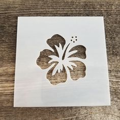 a cutout of a flower on top of a wooden table next to a piece of paper