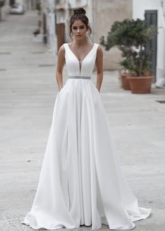 a woman in a white dress standing on the street