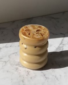 a yellow vase sitting on top of a marble counter