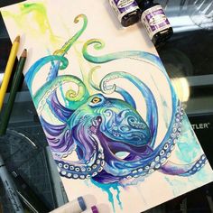 an octopus painting with watercolors on paper next to markers and paintbrushes